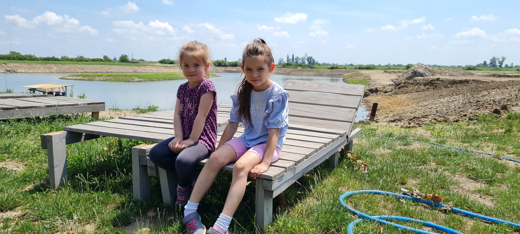 Two girls sitting down on a deck chair