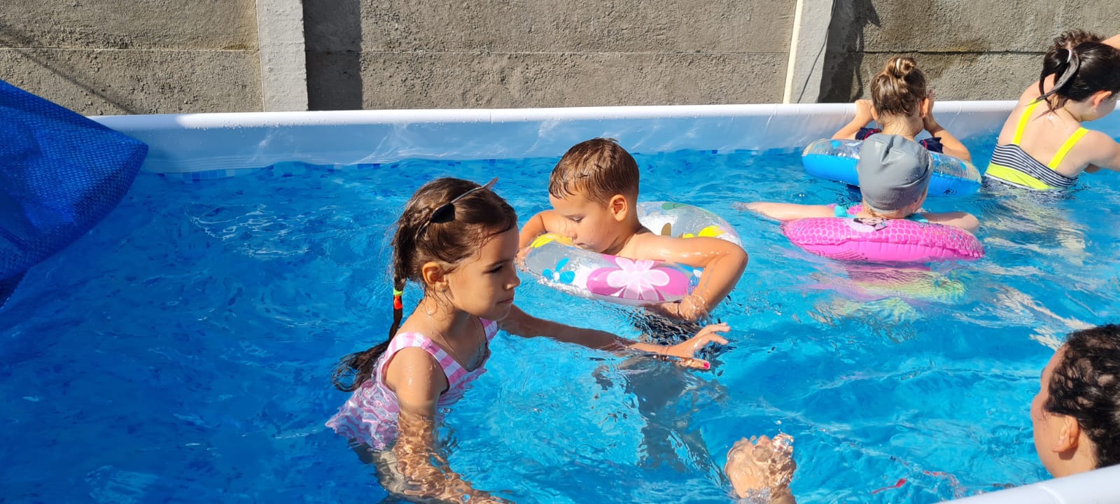 Five kids playing in a swimmingpool