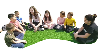 Children sitting down in a semicircle in the garden