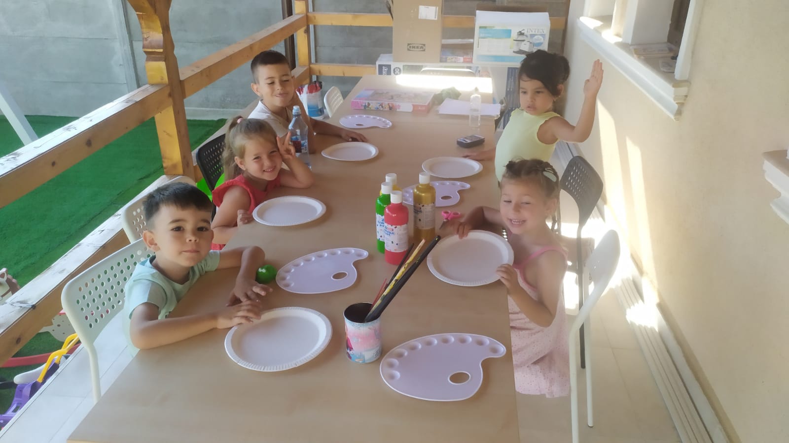 Five kids at a table on a terrace having lunch