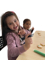 Two girls sitting at a table doing arts and crafts